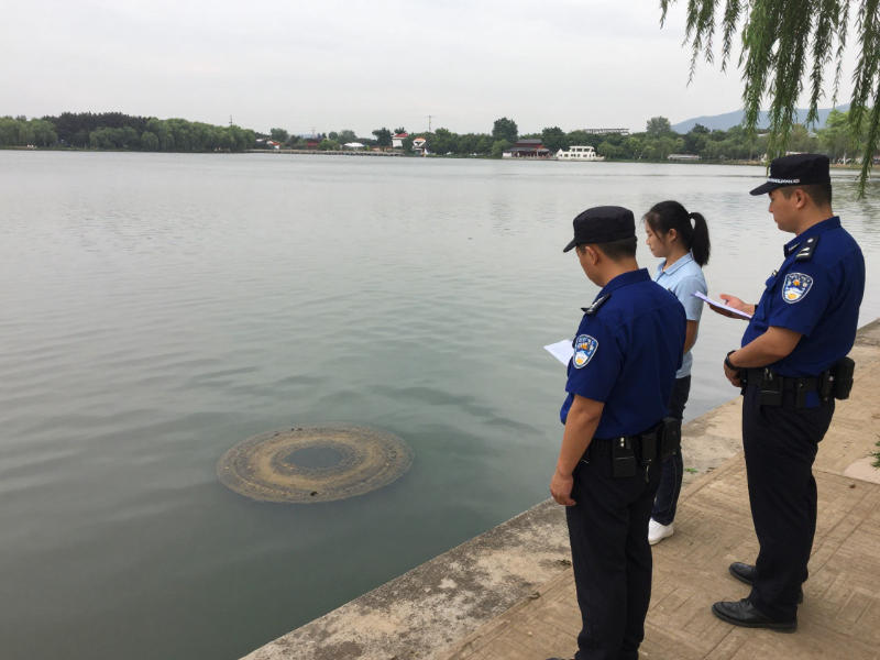 应急监督执法人员在观测河道污水排放